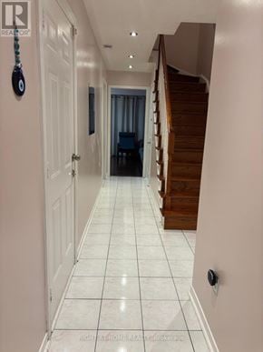 Mississauga (Lisgar) apartment for rent - A hallway with white tiled floors and a wooden staircase.