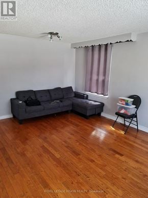 Toronto (Woburn) apartment for rent - A living room with a grey couch and a small ottoman.