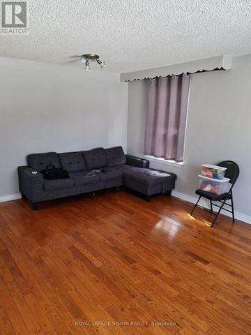 Toronto (Woburn) apartment for rent - A living room with a grey couch and a small ottoman.