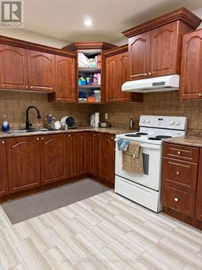 Toronto (Woburn) apartment for rent - A kitchen with wooden cabinets and a white stove top oven.