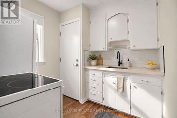 London East (East N) multi-family for rent - A white kitchen with a black stove top and white cabinets.