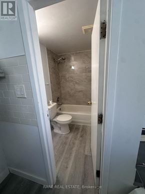 Toronto (South Parkdale) multi-family for rent - A bathroom with a toilet, tub, and sink.