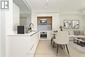 Toronto (Annex) condo for rent - A modern kitchen with white cabinets and a black speaker on the counter.