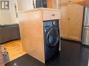 St. John's apartment for rent - A washing machine is built into a wooden cabinet in a modern kitchen.