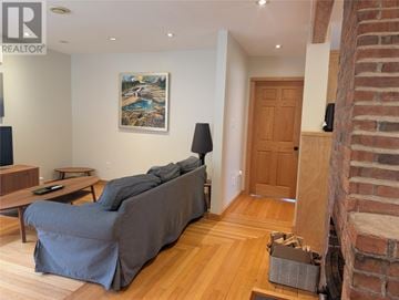 St. John's apartment for rent - A living room with a grey couch and a painting on the wall.