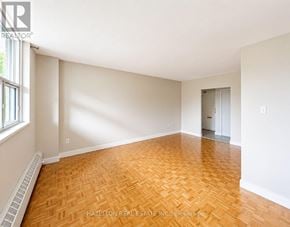 Toronto (Victoria Village) condo for rent - A room with a wooden floor and white walls.