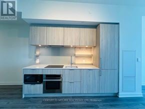 Mississauga (Port Credit) condo for rent - A modern kitchen with wooden cabinets and appliances.
