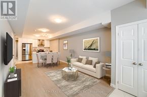 Kitchener townhouse for rent - A living room with a couch, a dining table, and a television.