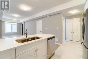 Kitchener townhouse for rent - A modern kitchen with white countertops and stainless steel appliances.