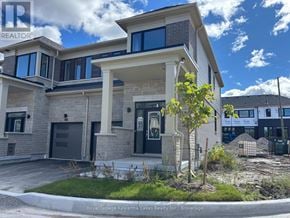 Kawartha Lakes (Lindsay) townhouse for rent - A modern house with a large front yard and a tree in the foreground.