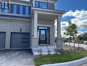 Kawartha Lakes (Lindsay) townhouse for rent - A modern house with a grey garage door and a black door.