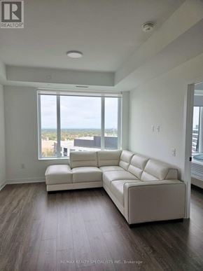 Mississauga (Central Erin Mills) condo for rent - A white couch in a room with a large window.