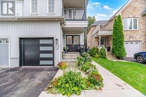 Mississauga (Meadowvale Village) apartment for rent - A house with a garage and a driveway with plants.