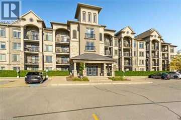 Milton condo for rent - A large apartment complex with a parking lot in front.
