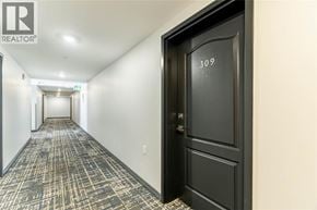 Milton condo for rent - A hallway with a black door and a sign that says 309.