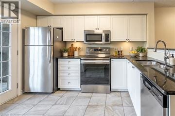 Milton condo for rent - A modern kitchen with a stainless steel refrigerator, microwave, and oven.