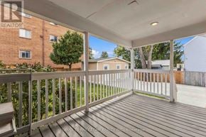 Oshawa (Central) apartment for rent - A wooden deck with a white railing and a bench.