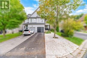 Mississauga (Meadowvale Village) apartment for rent - A white house with a grey roof and a driveway in front of it.