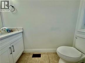 Cambridge apartment for rent - A white toilet in a bathroom with a white cabinet and a white towel.