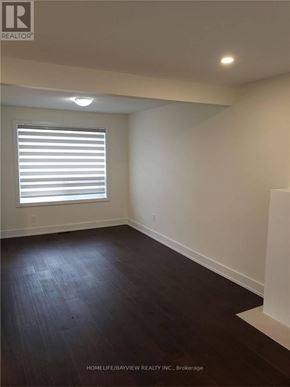 Vaughan (Maple) apartment for rent - A room with wooden floors and a window with blinds.