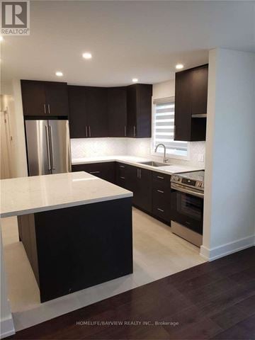 Vaughan (Maple) apartment for rent - A modern kitchen with dark brown cabinets and white countertops.