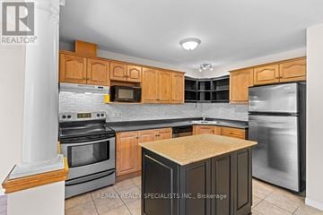 Kitchener townhouse for rent - A kitchen with wooden cabinets and stainless steel appliances.