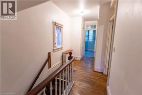 Hamilton apartment for rent - A hallway with a wooden staircase and white walls.