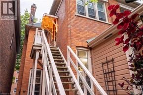 Hamilton apartment for rent - A red brick house with a white staircase leading to the second floor.