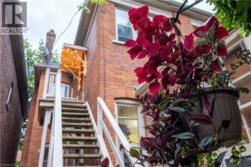 Hamilton apartment for rent - A house with a red brick exterior and a white staircase leading to the second floor.