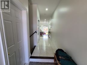 Milton (Cl Clarke) townhouse for rent - A hallway with a bag on the floor and a door on the left.