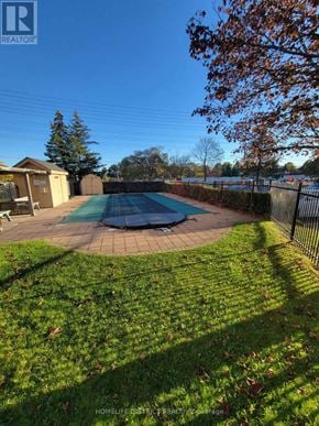 Ajax (Central West) condo for rent - A backyard with a pool and a fence.