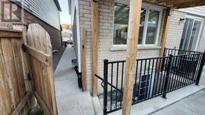 Brampton (Northwest Brampton) apartment for rent - A wooden gate is open to a patio with a black railing.