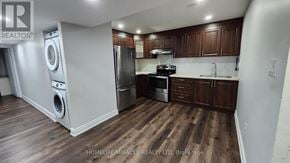 Brampton (Northwest Brampton) apartment for rent - A kitchen with wooden floors and dark brown cabinets.
