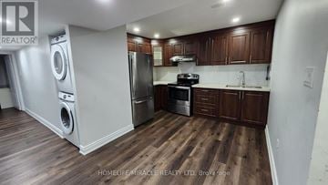 Brampton (Northwest Brampton) apartment for rent - A kitchen with wooden floors and dark brown cabinets.