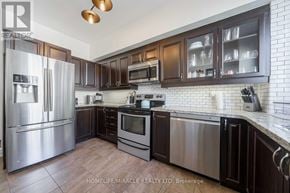 Burlington (Mountainside) townhouse for rent - A kitchen with dark brown cabinets and stainless steel appliances.