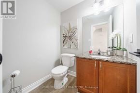 Burlington (Mountainside) townhouse for rent - A bathroom with a toilet, sink, and a mirror.