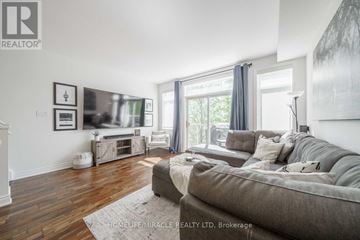 Burlington (Mountainside) townhouse for rent - A living room with a grey couch and a wooden floor.