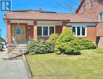 Toronto (Downsview-Roding-Cfb) apartment for rent - A house with a red brick exterior and a green lawn in front.