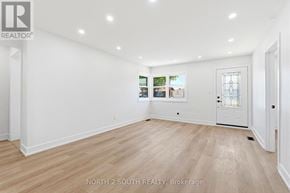 Hamilton (Stoney Creek) apartment for rent - A white room with wood flooring and a door on the right side.