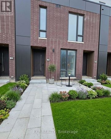 St. Catharines (Oakdale) townhouse for rent - A modern brick building with a garden in front.