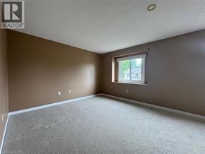 Kitchener townhouse for rent - A room with a window and a carpeted floor.