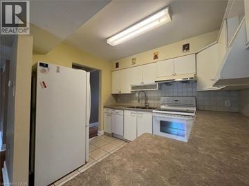 Kitchener townhouse for rent - A kitchen with a white fridge and white cabinets.