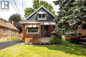 Hamilton apartment for rent - A small brick house with a black awning and a black truck parked in front.