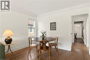 Hamilton apartment for rent - A dining room with a table set for two and a cat in the hallway.