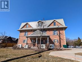 Oshawa (Eastdale) multi-family for rent - A large brick house with a porch and a tree in front.