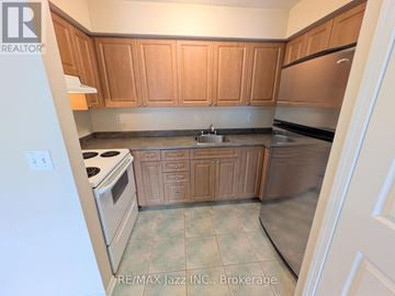 Oshawa (Eastdale) multi-family for rent - A kitchen with wooden cabinets and a stove top oven.