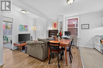 Ottawa multi-family for rent - A living room with a brown couch and a wooden table.