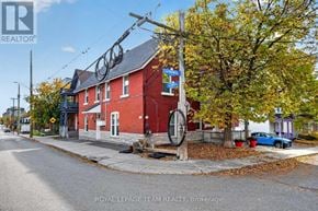 Ottawa multi-family for rent - A red brick building with a sign that says "Royal LePage Team Realty, Brokerage" in front of it.