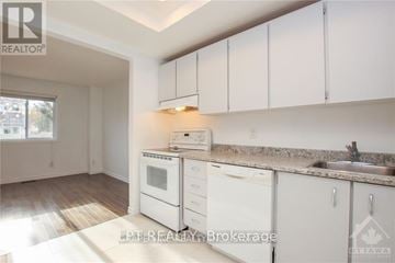 Ottawa apartment for rent - A kitchen with white cabinets and appliances is for sale.