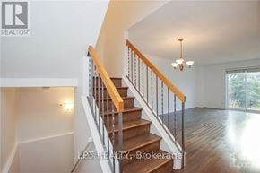 Ottawa apartment for rent - A staircase with a wooden handrail and white balusters leads to a bright room.